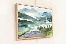 Load image into Gallery viewer, 24” x 36" original watercolor painting on canvas in 26" x 38" natural maple solid wood floater frame. Abstract landscape of foggy misty mountain layers with pine trees in an expressive, impressionist, loose, watery, ethereal, minimalist, modern, moody style by contemporary fine artist Elizabeth Becker. Inspired by Asheville, North Carolina or Colorado. Muted monochromatic blue, green and white colors.
