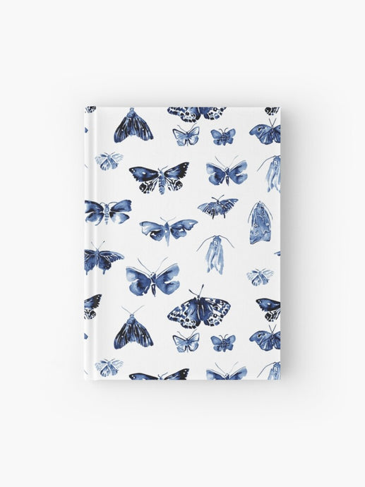 Hardcover journal featuring original hand-painted watercolor painting by artist Elizabeth Becker. Ruled line, graph or blank pages. Blue and white colors. Vintage moth or butterfly pattern. Insects design. 