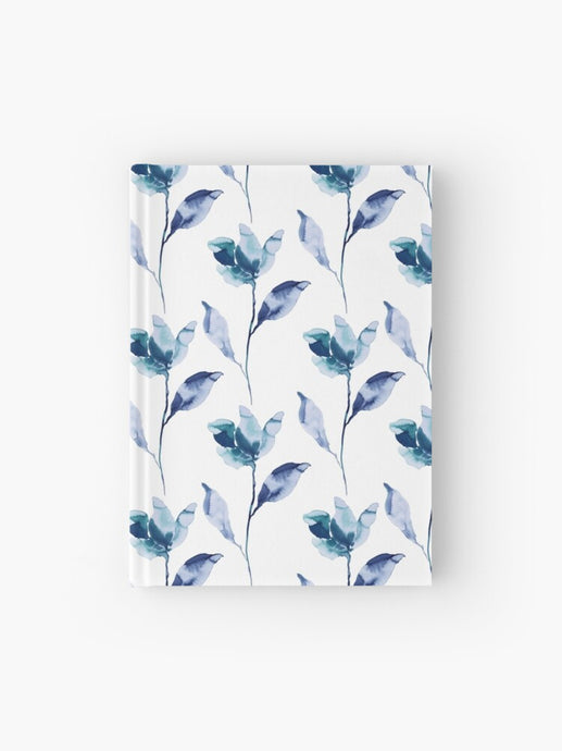 Hardcover journal featuring original hand-painted watercolor painting by artist Elizabeth Becker. Ruled line, graph or blank pages. Monochromatic blue, purple and white colors. Botanical flowers and leaves. Floral design.